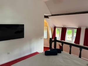 a bedroom with a bed and a tv on the wall at Chambre privée Moret Sur Loing in Moret-sur-Loing