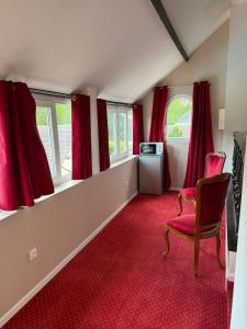 a room with red carpet and red curtains and a chair at Chambre privée Moret Sur Loing in Moret-sur-Loing