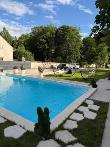 a teddy bear sitting next to a swimming pool at Chambre privée Moret Sur Loing in Moret-sur-Loing