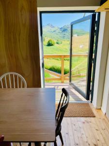 a wooden table and chair in front of a sliding glass door at Nykmark - Eco House - Room Selva in Bøstad