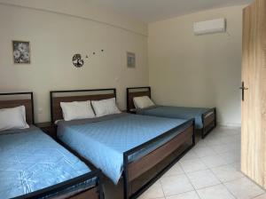a bedroom with two beds with blue sheets at Casa Koutrea in Kastanéa