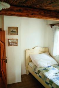 a bedroom with a bed with a wooden ceiling at Zenovna - Roubená chaloupka in Krásná +26 photos