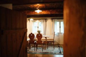 a dining room with a table and chairs and windows at Zenovna - Roubená chaloupka in Krásná