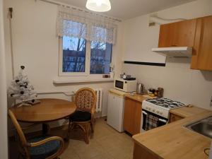 a kitchen with a small table and a kitchen with a stove at Apartament Kościelna, dwie oddzielne sypialnie in Białystok