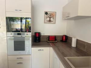a kitchen with white cabinets and a counter top at Maison avec piscine proche plage in Les Trois-Îlets