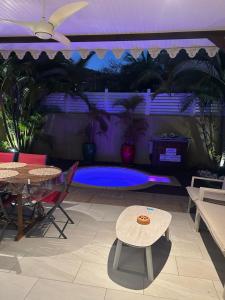 a patio with a table and chairs and a pool at Maison avec piscine proche plage in Les Trois-Îlets