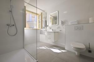 a white bathroom with a shower and a toilet at U Schnellu in Prague