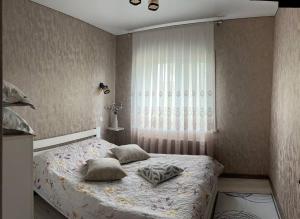 a bedroom with a bed with pillows and a window at Lake Relax in Chernihiv