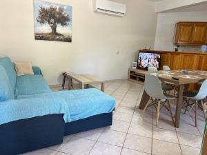 a living room with a bed and a table and a television at Casa Koutrea in Kastanéa