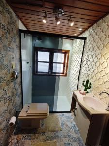 a bathroom with a shower and a sink and a toilet at Chalé Deruci in Nova Friburgo +18 photos
