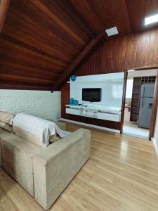 a living room with a couch and a flat screen tv at Chalé Deruci in Nova Friburgo