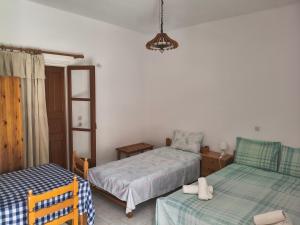 a bedroom with two twin beds and a lamp at Gliko Onoiro in Lefkos Karpathou