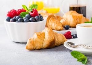 a table with croissants and berries and a cup of coffee at Two Trees Inn in Ledyard Center