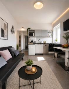 a living room with a black couch and a table at Apartment "MANNA in Korčula