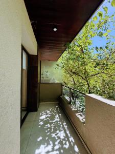 a balcony of a building with a window and a tree at Andes Nomad Mendoza in Godoy Cruz