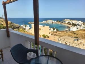 a balcony with a blue chair and a view of the ocean at Gliko Onoiro in Lefkos Karpathou