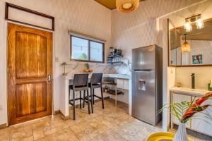 a kitchen with a refrigerator and a table with chairs at Beachfront Studio - King Bed - Fast WiFi - AC in Cocles +18 photos