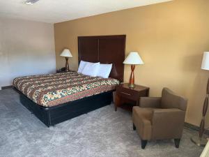 a hotel room with a bed and a chair at Crown Lodge in Kansas City