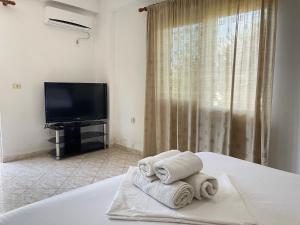 a bedroom with a bed and a tv and towels at Dimora Seaside Apartments in Ksamil
