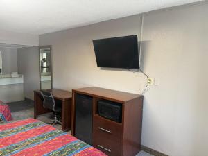 a hotel room with a bed and a tv on a wall at Crown Lodge in Kansas City