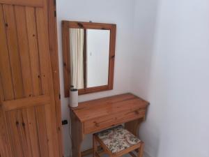 a bathroom with a wooden dressing table and a mirror at Gliko Onoiro in Lefkos Karpathou