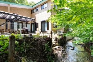 a house with a creek in front of it at HARMONIA 那須 Nas-MAX26名-川遊び-BBQ-カラオケのできる宿 in Nasu