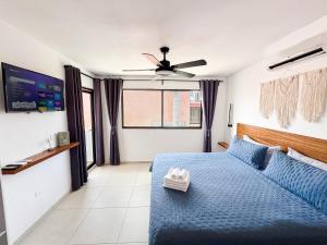 a bedroom with a blue bed and a ceiling fan at TAYGA STUDIOS Cancun in Cancún