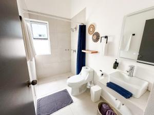a white bathroom with a toilet and a sink at TAYGA STUDIOS Cancun in Cancún +73 photos