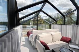 a glass house with a couch and a bed at Lunar igloos - Kaamos in Karkku
