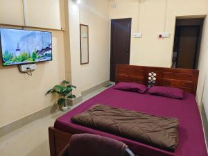 a bedroom with a large bed and a flat screen tv at JM Niwas in Guwahati