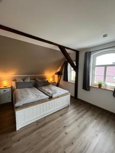 a bedroom with a white bed and two windows at Haus Wally - Ferienwohnungen in Klitten