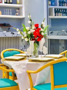 a table with a vase of red and white flowers at hotel la valeureuse mère in Yaoundé