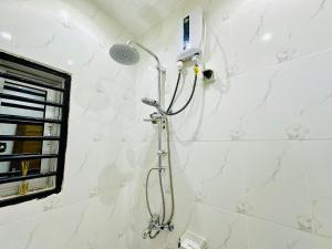 a shower in a bathroom with a shower head at hotel la valeureuse mère in Yaoundé