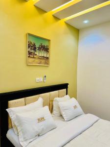 a hotel room with a bed with white pillows at hotel la valeureuse mère in Yaoundé