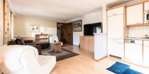 a living room with a couch and a kitchen at Beim Franz in Lermoos
