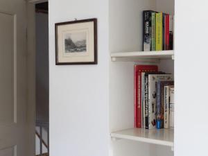 a book shelf with books and a picture at Ferienwohnung Hasenkate II - Boldevitzer Rügenkaten in Parchtitz +8 photos