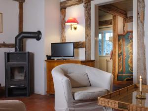 a living room with a chair and a television at Ferienwohnung Hasenkate II - Boldevitzer Rügenkaten in Parchtitz