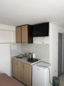 a small kitchen with a sink and a refrigerator at Apartments Sole1 in Sutomore