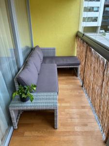 a couch on a balcony with a plant at Viimsi Apartment in Haabneeme