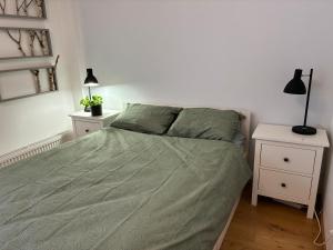 a bedroom with a bed with a green comforter at Viimsi Apartment in Haabneeme