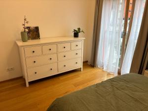 a bedroom with a dresser with two plants on it at Viimsi Apartment in Haabneeme