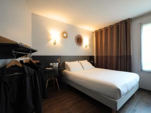 a hotel room with a bed and a desk at Hotel Gascogne in Toulouse