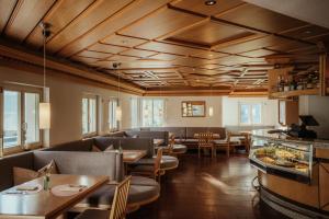 a restaurant with couches and tables and chairs at Antholzer Wildsee Haus in San Giuseppe in Anterselva