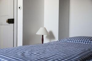 a bedroom with a blue bed and a lamp at Ferienwohnung Herrenhaus Linker Seitenflügel II - Boldevitzer Rügenkaten in Parchtitz