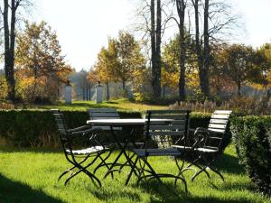 a picnic table and chairs sitting in the grass at Ferienwohnung Herrenhaus Linker Seitenflügel II - Boldevitzer Rügenkaten in Parchtitz +6 photos