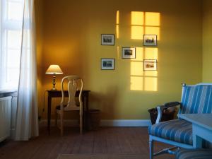 a room with a table and a chair and a lamp at Ferienwohnung Herrenhaus Linker Seitenflügel II - Boldevitzer Rügenkaten in Parchtitz