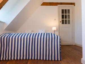 a bedroom with a bed with blue and white stripes at Ferienwohnung Blücherkate II - Boldevitzer Rügenkaten in Parchtitz