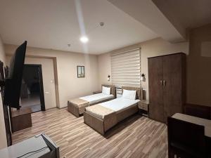 a bedroom with two beds and a flat screen tv at Tourist inn Tashkent in Toshkent-Passajir Bekati