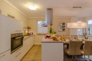 a kitchen with white cabinets and a dining table at Grosse Kirr in Zingst