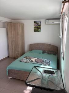 a small bedroom with a bed and a glass table at Apartments Sole1 in Sutomore